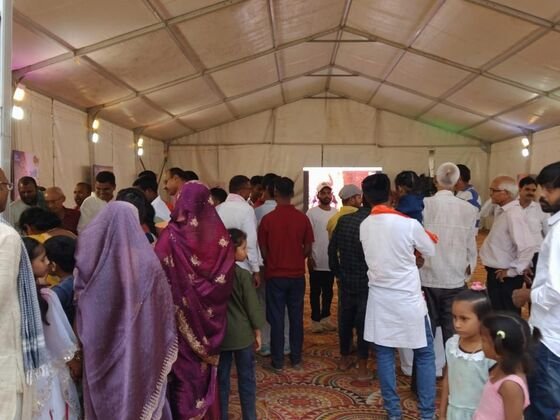 Visitors gathered inside the Sun Neo tent watching an on-screen broadcast